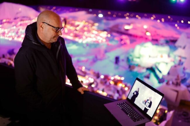 Steinar Kristoffersen med en bærbar datamaskin foran den opplyste Pepperkakebyen i 2020.